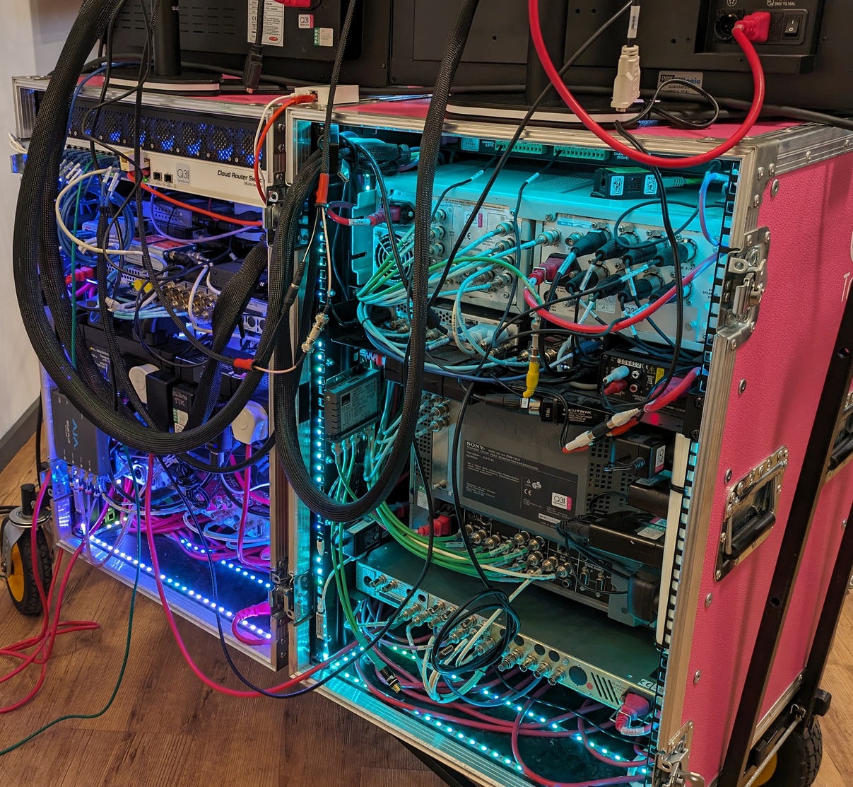 BigPinkDemoKit- Main Racks - REAR (Small) read view of the fundamentals and HD demo racks - lots of wiring and equipment connections can be seen. The rear of each rack is illuminated with LED light strips mounted around all sides